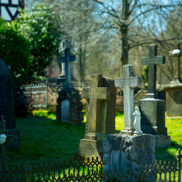 Blick auf den Kirchhof bei der Kirche aus Niederhörlen mit gesammelten Grabsteinen