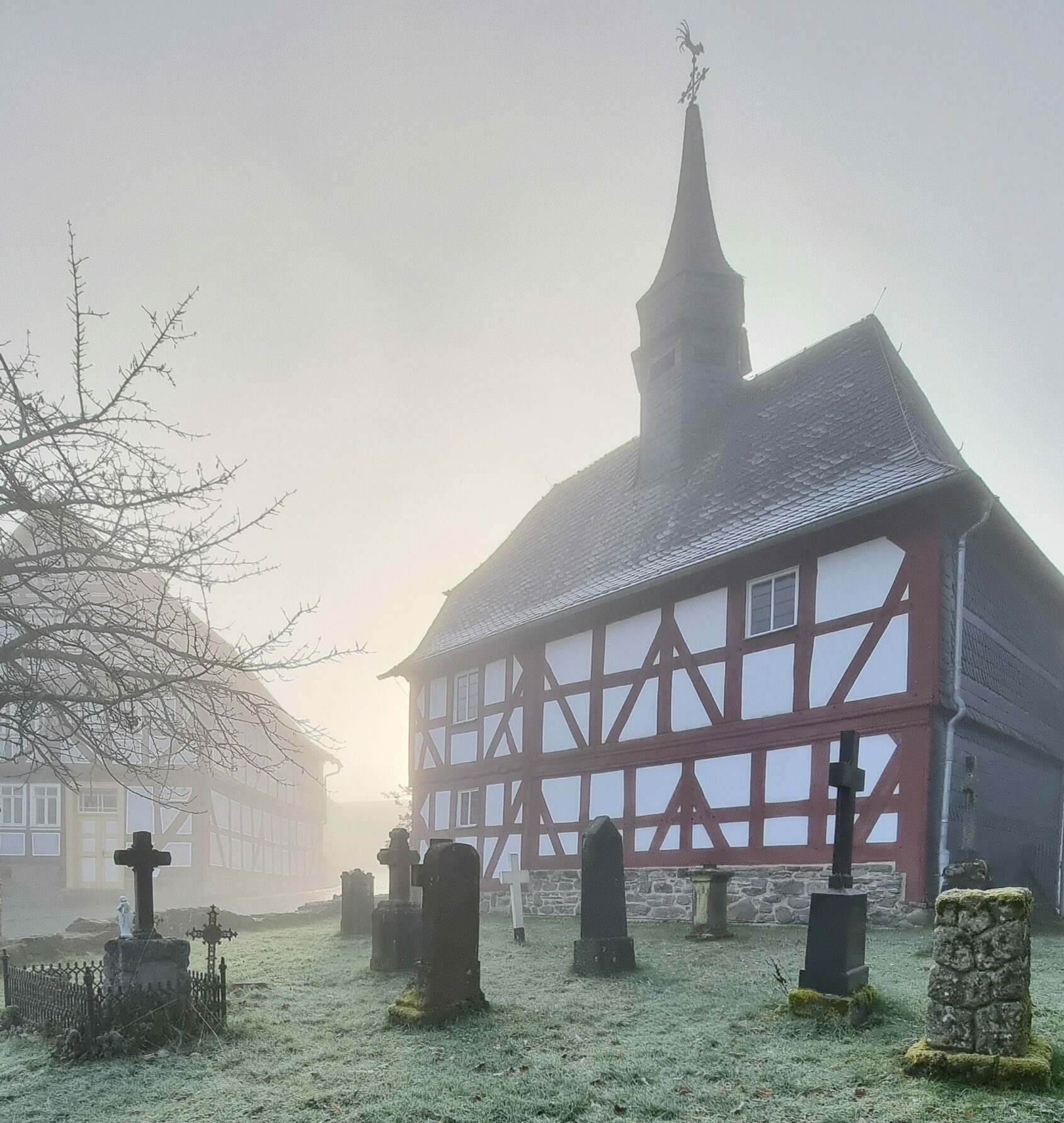 Kirche aus Niederhörlen mit Kirchhof im Nebel