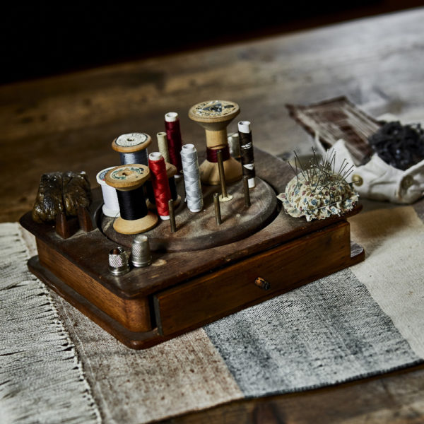 Detailaufnahme von verschiedenem Nähgarn auf einem Holztisch