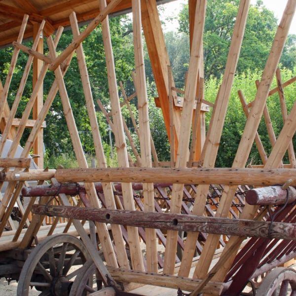 Blick ins Schaudepot für landwirtschaftliche Großgeräte: Dreschwagen aus Holz, Nahaufnahme.