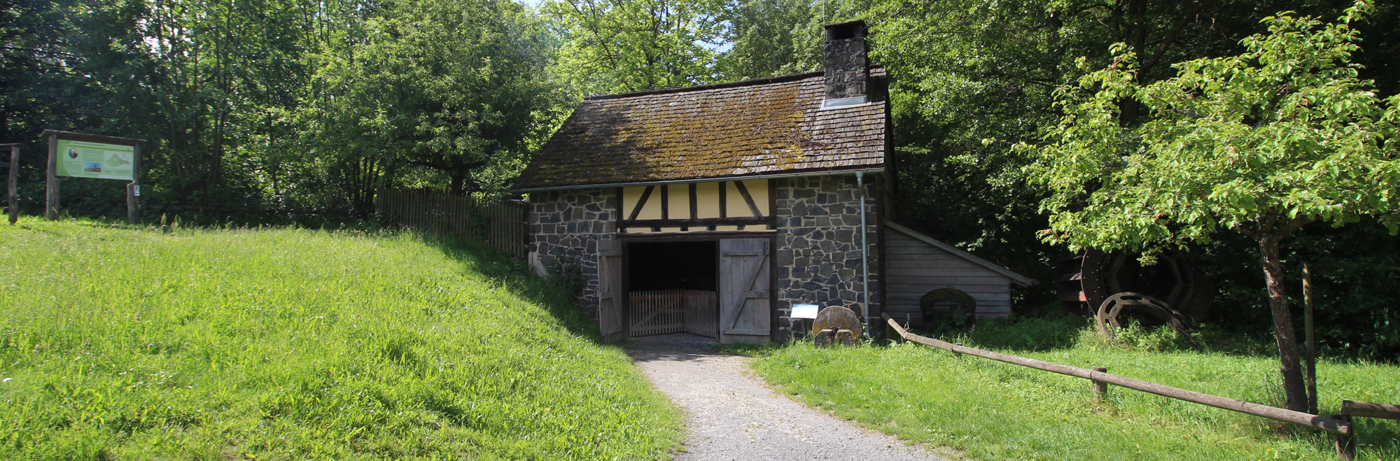 Gemauerte Hütte mit Holztor am Fuß eines kleinen Hügels