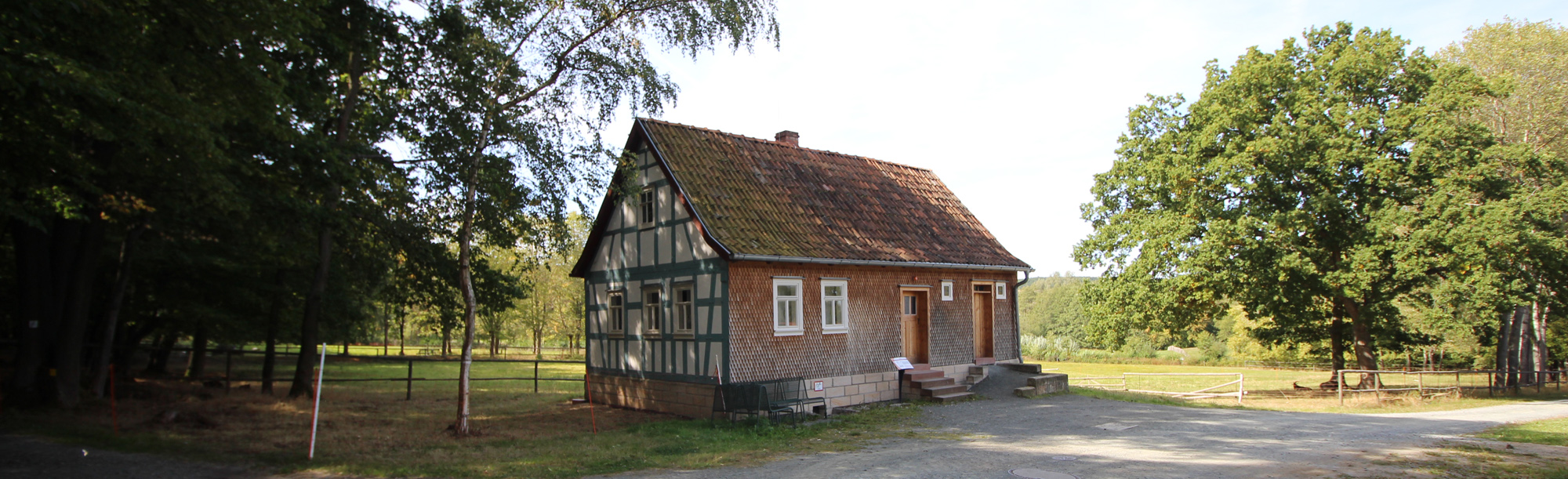 Das Altenteilerhaus aus Sieblos steht in der Baugruppe Osthessen. Die linke Seite ist eine Fachwerk-Fassade. An die Vorderseite wurden Holzschindeln angebracht.