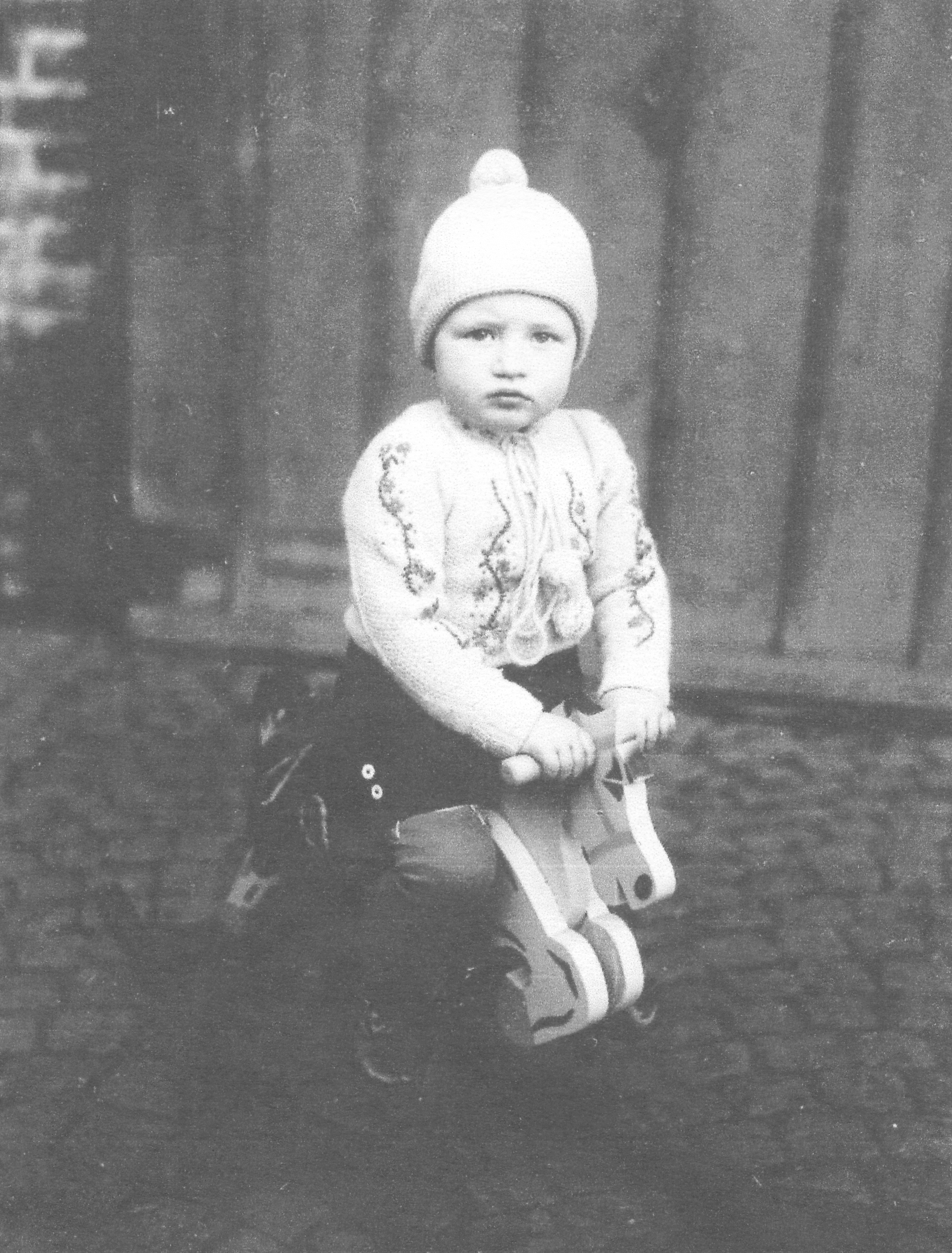 Historisches Foto, kleiner Junge mit Mütze auf einem Schaukelpferd