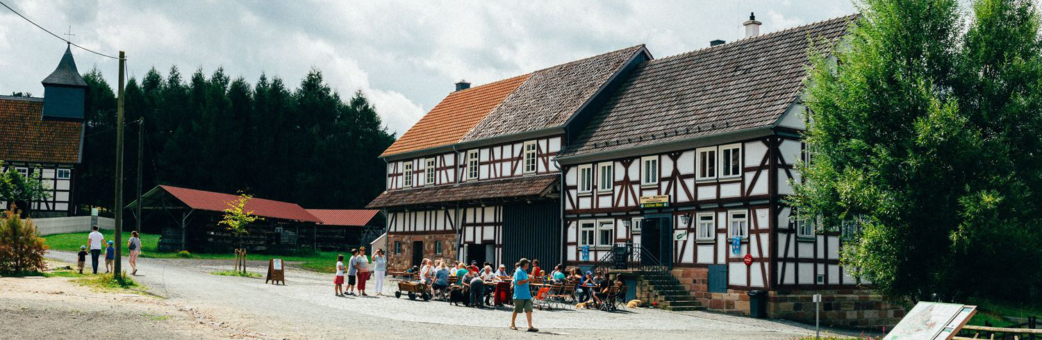 Das Fachwerkhaus beherbt die Martinsklause, ein Bistro. Davor stehen Sitzmöglichkeiten. Einige Museumsbesucher halten sich hier auf.