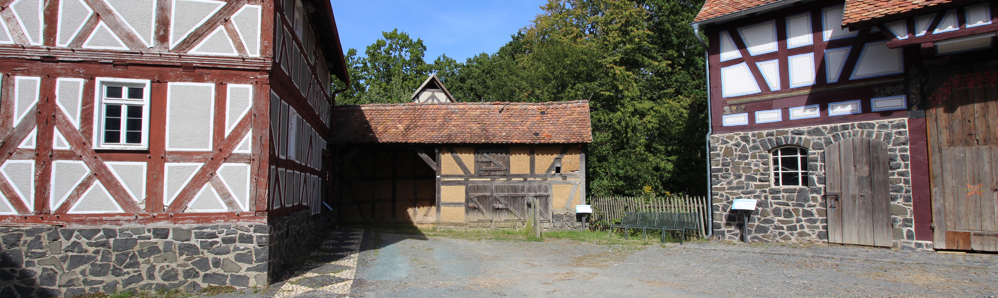 Das Fachwerkhaus hat einen Sockel aus Basaltsteinen mit Schuppenöffnungen im Erd- und Obergeschoss.