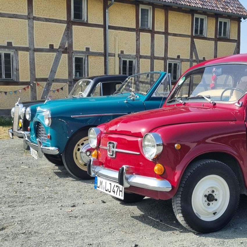 Autos vor einem Fachwerkhaus