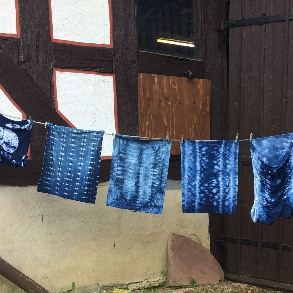 Wäscheleine mit quadratischen Tüchern, diese wurden in einem Blaufärbeworkshop eingefärbt.